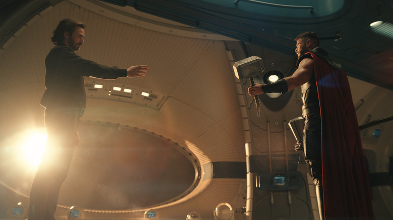 Chris Evans as Steve Rogers holds out his arm to Chris Hemsworth as Thor on a spaceship in front of a window in Avengers: Doomsday