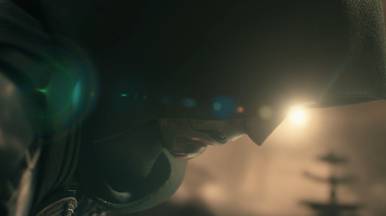 Robert Downey, Jr. as Doctor Doom crouching down with his hood over his mask in Avengers: Doomsday