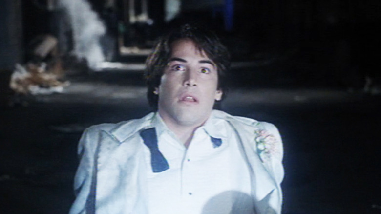 Keanu Reeves as Winston Connelly looks scared as he lays in an alley in The Night Before