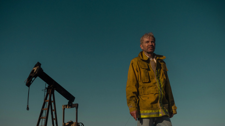 Billy Bob Thornton as Tommy stands in front of Oil Fountain on Landman