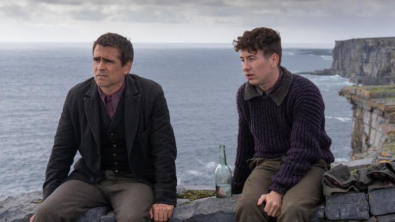 Padraic and Dominic sit on a rocky outcrop, with a bottle between the two of them.