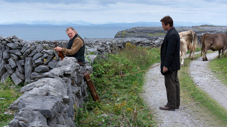 Brendan Gleeson and Colin Farrell stand by wall in The Banshees of Inisherin