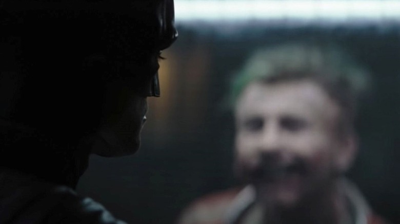 Batman looking at the Joker behind the glass