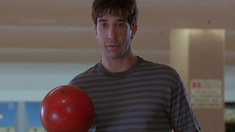 David Schwimmer's Tom Thompson stands holding a bowling ball in The Pallbearer
