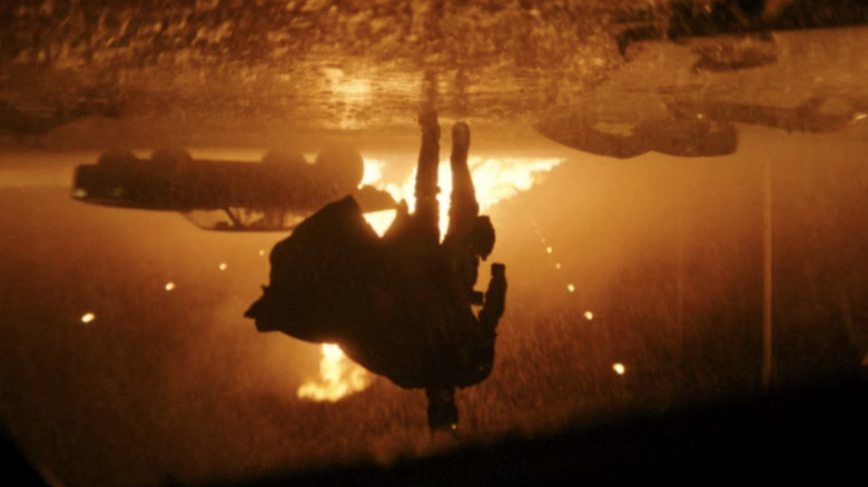 The Batman (2022), upside down shot of Batman advancing towards the Penguin's toppled car
