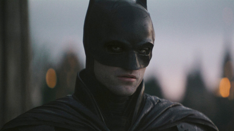 Batman standing atop a building early in the morning in The Batman