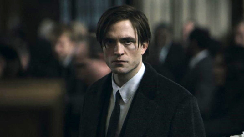 Bruce Wayne broods in a suit
