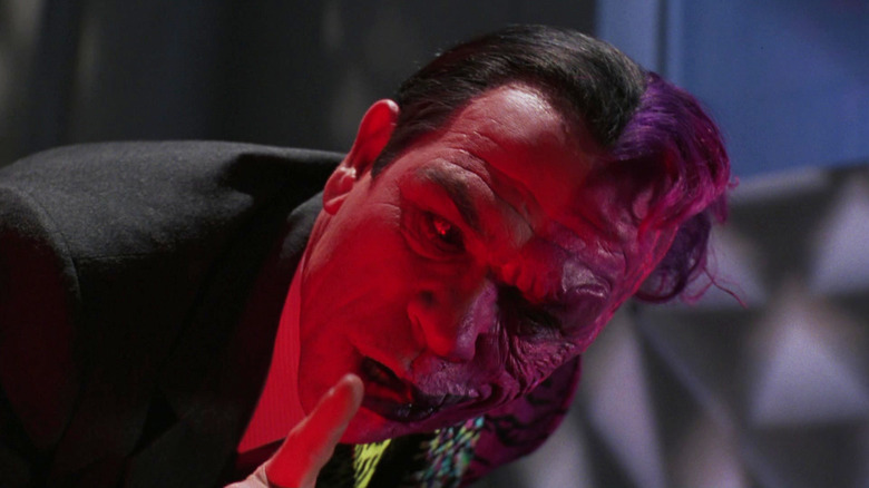 Tommy Lee Jones as Two-face raising a finger to his lips in Batman Forever