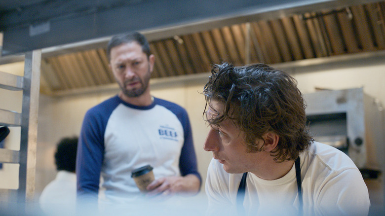 Richie standing behind a stressed out Carmy in the Beef kitchen on The Bear