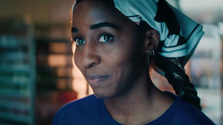 Ayo Edebiri as Sydney Adamu smiling in a kitchen in The Bear