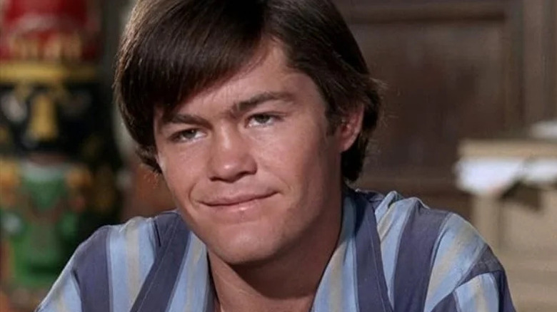 Micky Dolenz sorrindo e vestindo uma camisa listrada nos macacos