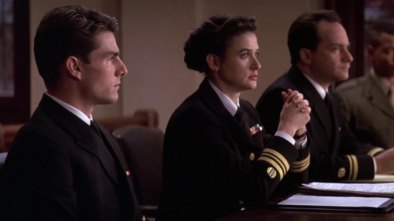 Tom Cruise como Daniel Kaffee e Demi Moore como Joanne Galloway sentada no tribunal em alguns homens bons