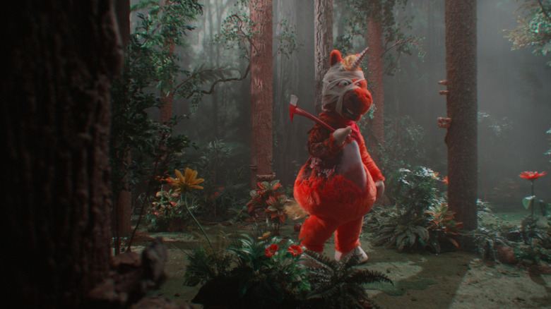 Buddy holds an axe in the woods in Buddy