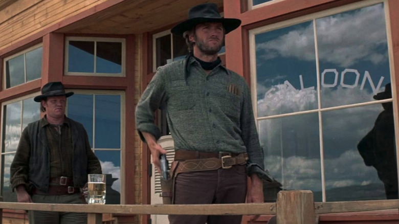 Clint Eastwood as The Stranger in High Plains Drifter, ready to draw his gun in front of a saloon