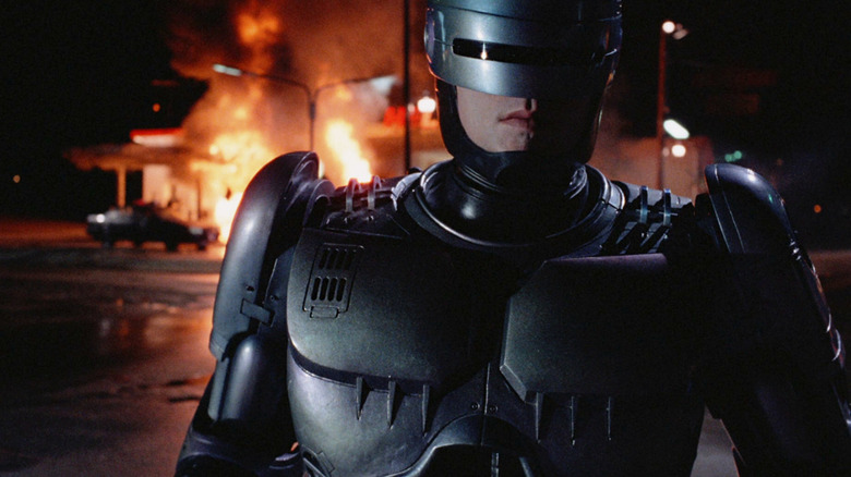 RoboCop walking away from a burning gas station