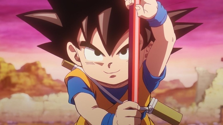 A younger Goku smiles holding his Power Pole in Dragon Ball Daima