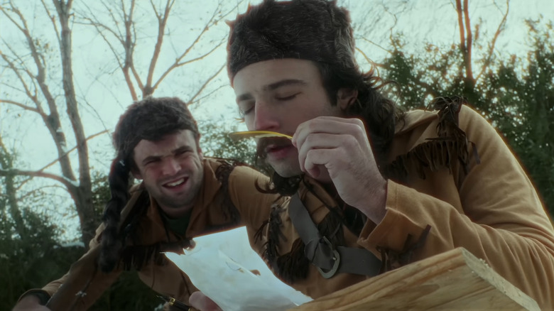 Owne Reiser sniffing a feather with Quentin Reiser looking on in Listers: A Slimpse Into Extreme Birdwatching