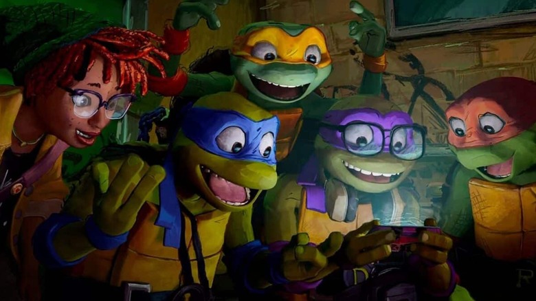 April and the Ninja Turtles gather around a glowing smartphone