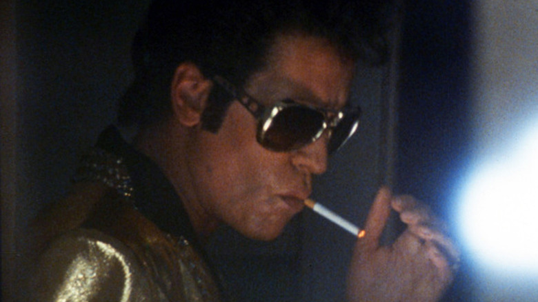 Val Kilmer lighting a cigarette as Elvis in True Romance