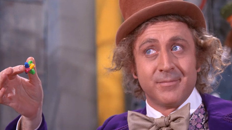 Gene Wilder as Willy Wonka eating candy in his chocolate factory