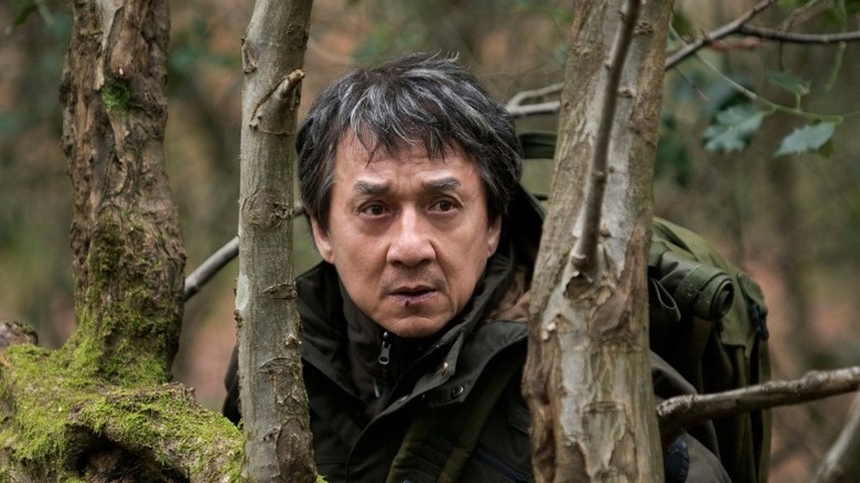 Jackie Chan hides behind trees in The Foreigner