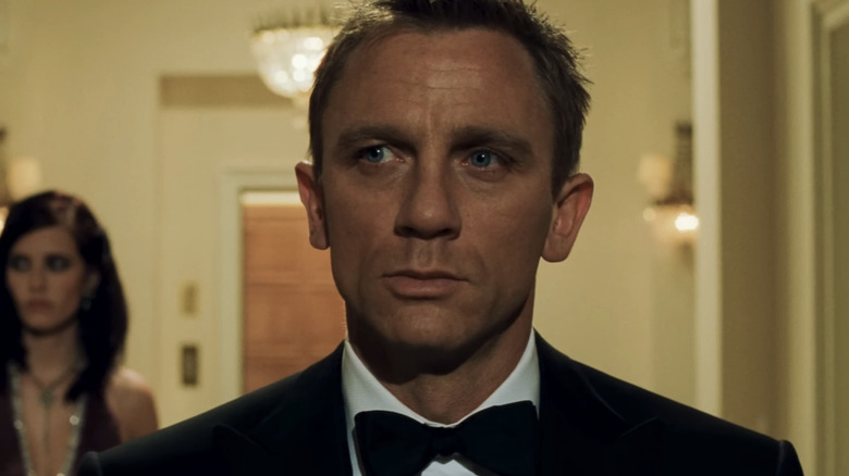 Daniel Craig's James Bond stands in a hotel hallway as Eva Green's Vesper Lynd stands behind him in Casino Royale