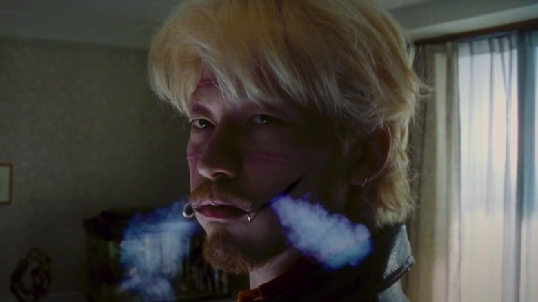 Tadanbu Asano blowing smoke through perforated cheeks
