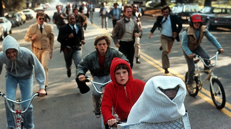 Elliott, ET, and friends riding bikes away from adults