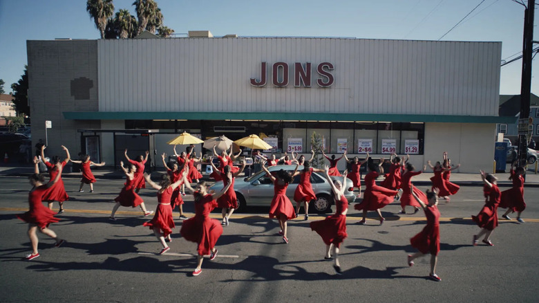 Large group of women wearing red dance in the street