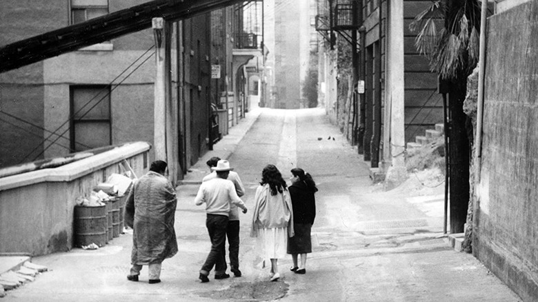 A group walks down a run-down city street