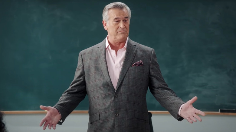 Bruce Campbell in a gray suit looking nonplussed