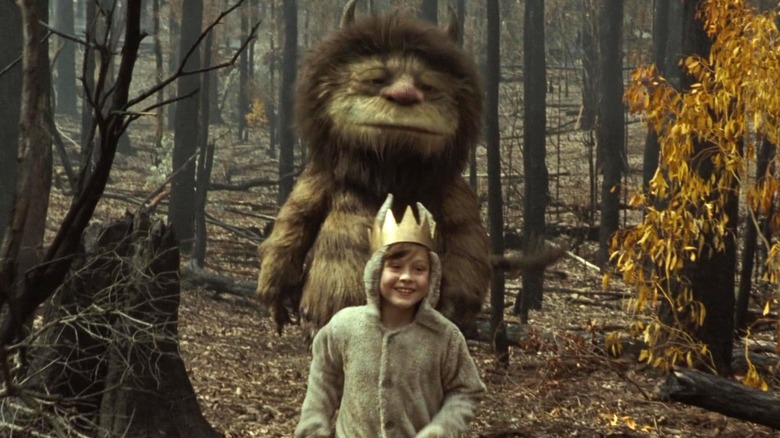 James Gandolfini as Carol stands in the woods behind Max Records as Max in his wolf suit in Where the Wild Things Are