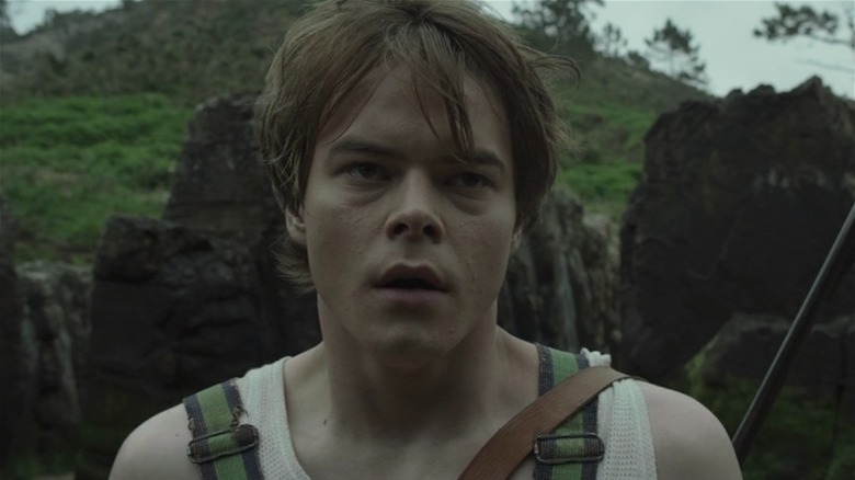 Charlie Heaton rocks tank top gun strapped to back