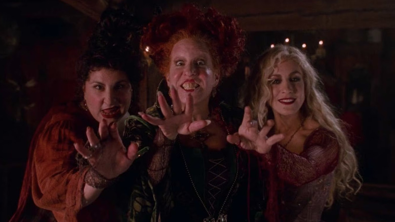 Kathy Najimy, Bette Midler, and Sarah Jessica Parker as the Sanderson Sisters, reaching towards the camera, on Hocus Pocus
