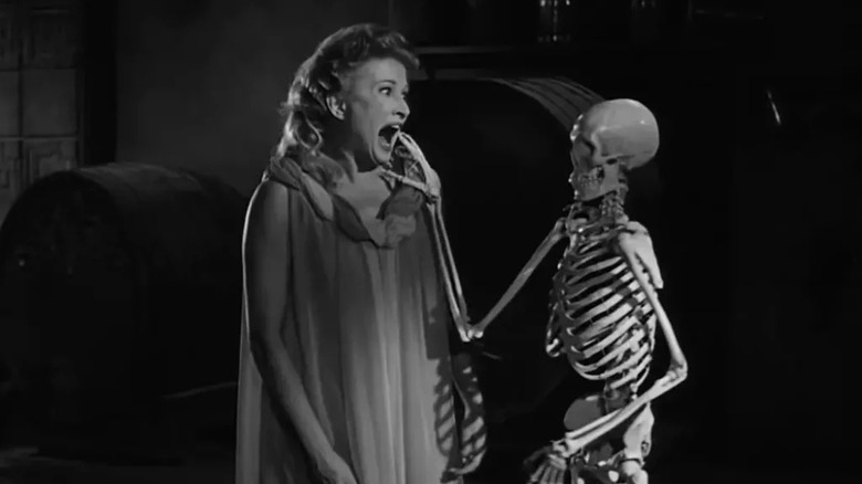 Annabelle Loren (Carol Ohmart) screams at a skeleton touching her shoulder in House on Haunted Hill (1959)