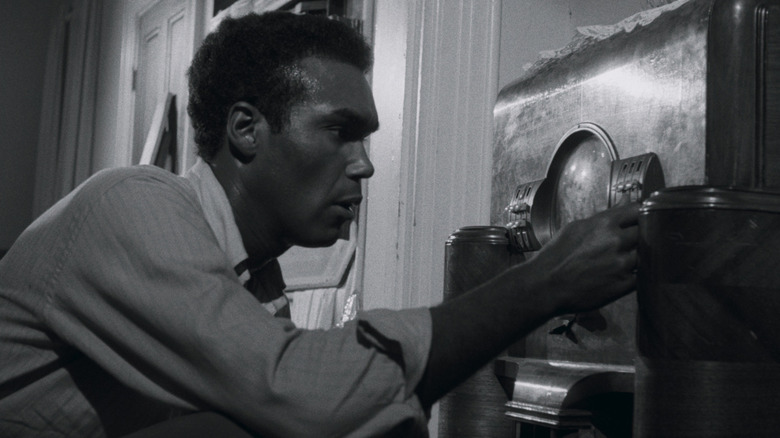 Ben (Duane Jones) tries to tune the radio in Night of the Living Dead (1968)