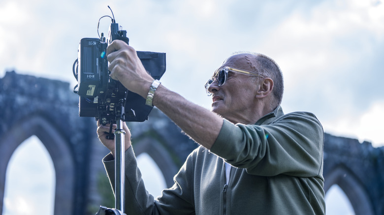 Director Danny Boyle looking through a camera setup on the set of 28 Years Later