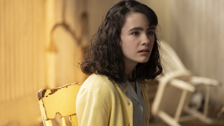 Clara Stack as Lilly Bainbridge sitting in a chair and looking concerned in It: Welcome to Derry