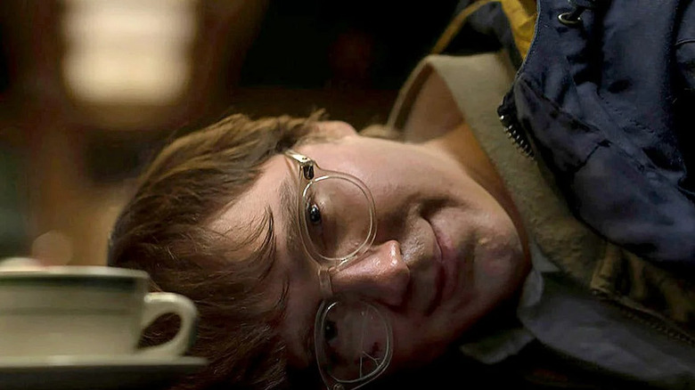 Paul Dano smiling, head resting on counter