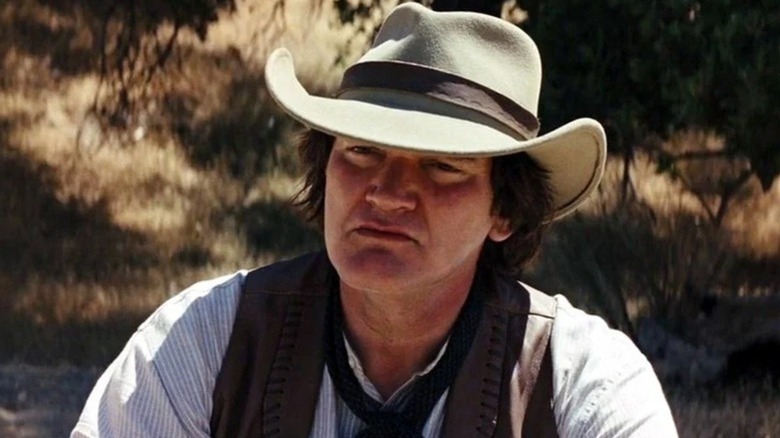 Frankie (Quentin Tarantino) sitting down in "Django Unchained."