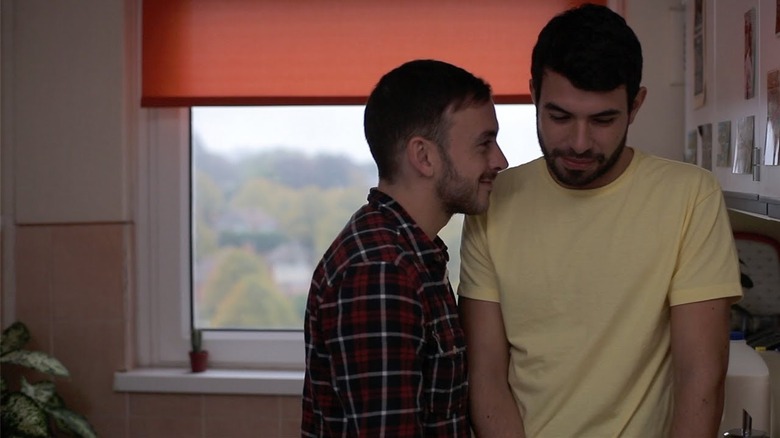 Glen standing close to Russell in kitchen