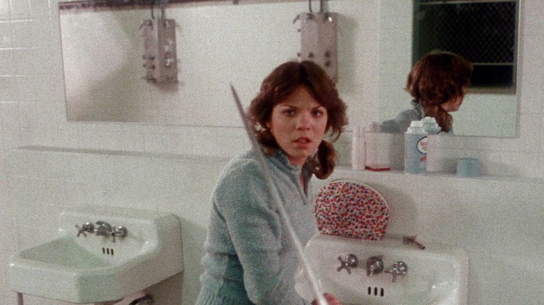 A woman is threatened by a javelin in a bathroom