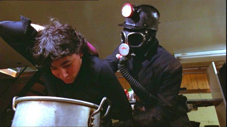 The killer pushes a person's head into a pot