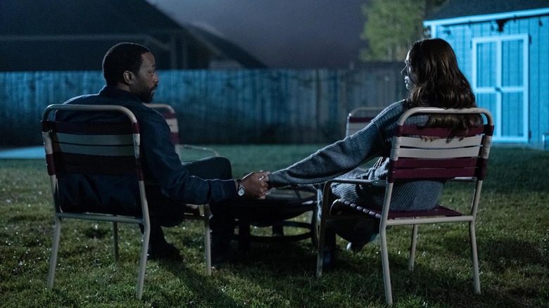 Chiwetel Ejiofor as Marty holding hands with Karen Gillan as Felicia in a backyard in The Life of Chuck