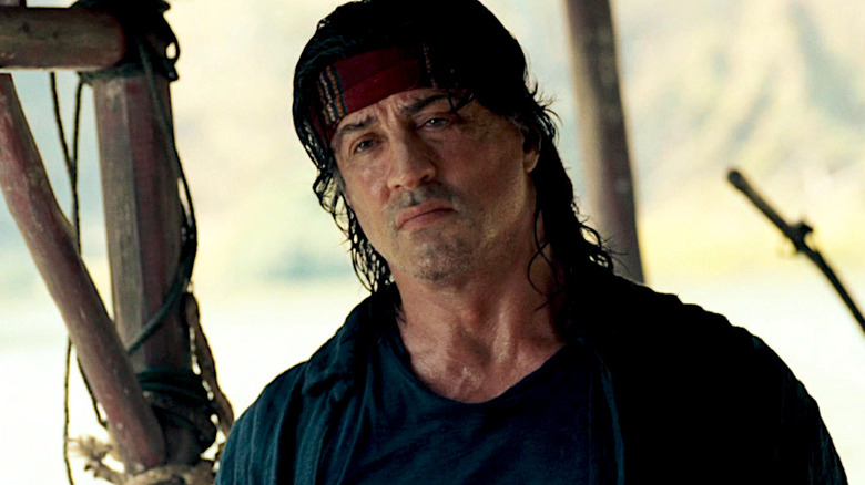 Sylvester Stallone looks angry at the camera in Rambo