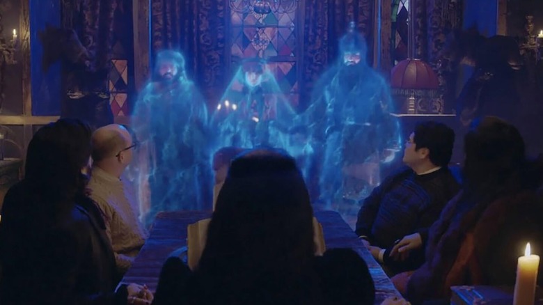 The gang sits at a table, looking on at ghostly versions of themselves