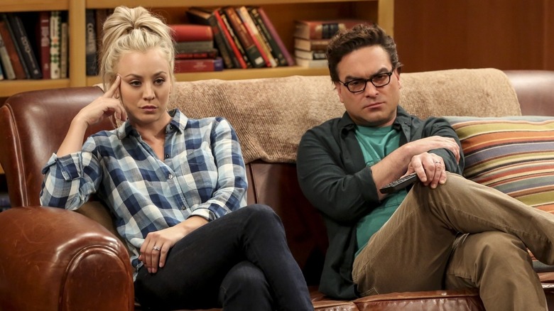 Leonard y Penny están en el sofá luciendo molestos por The Big Bang Theory.