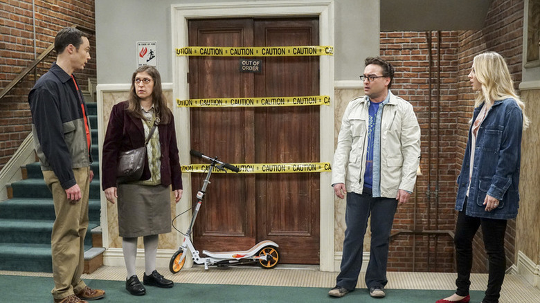 Sheldon Amy Leonard and Penny talking in front of the broken elevator on The Big Bang Theory