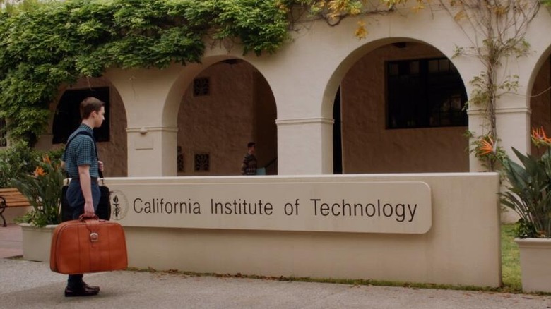 Sheldon holding a big suitcase looking at the Caltech sign on Young Sheldon