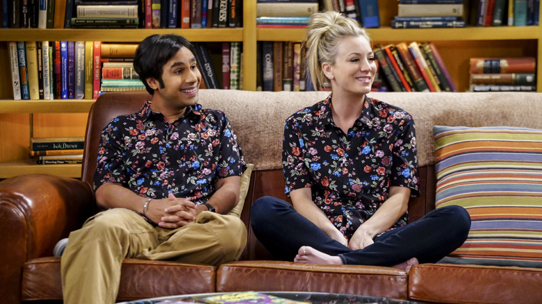 Raj and Penny in matching floral shirts sitting on the couch in The Big Bang Theory